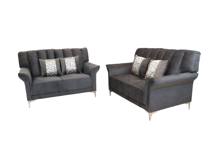 Conjunto de dos sofás color gris con cojines decorativos y patas metálicas sobre fondo blanco.