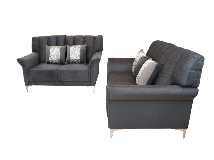 Conjunto de dos sofás color gris con cojines decorativos y patas metálicas sobre fondo blanco.