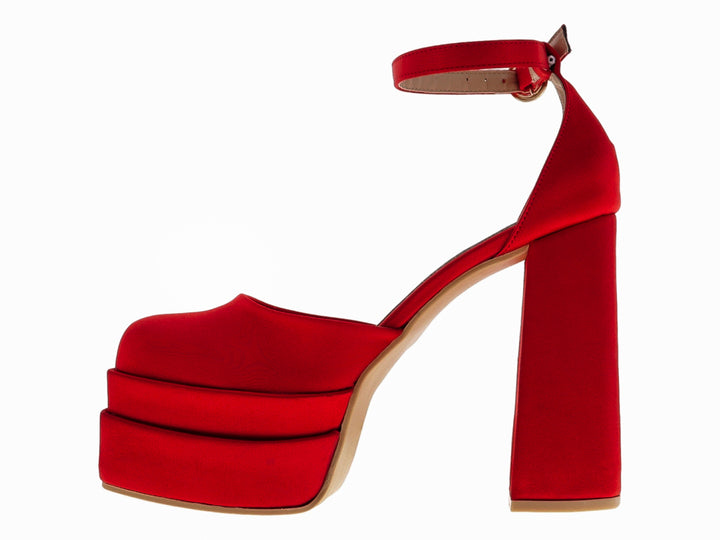 Zapato de tacón plataforma color rojo en material raso con correa al tobillo.