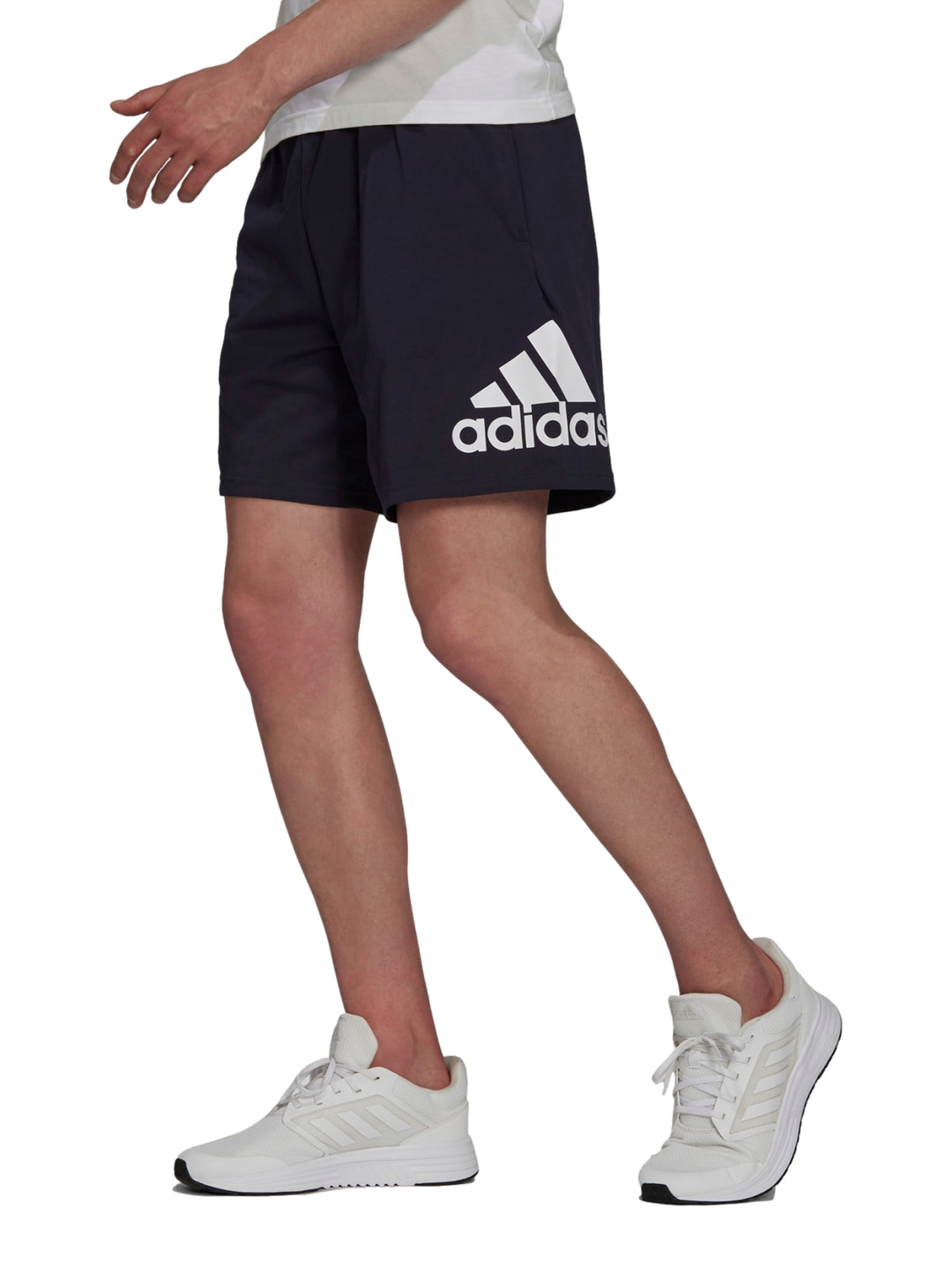 Hombre vistiendo pantalones cortos deportivos Adidas en color azul marino con logo blanco lateral.