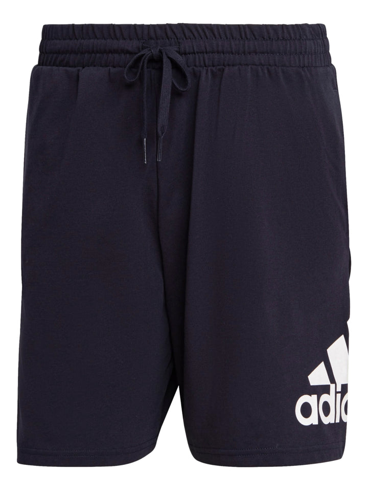Hombre vistiendo pantalones cortos deportivos Adidas en color azul marino con logo blanco lateral.