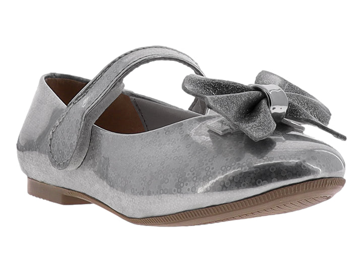 Zapato plano color plata brillante para niña con moño decorativo y correa de ajuste.