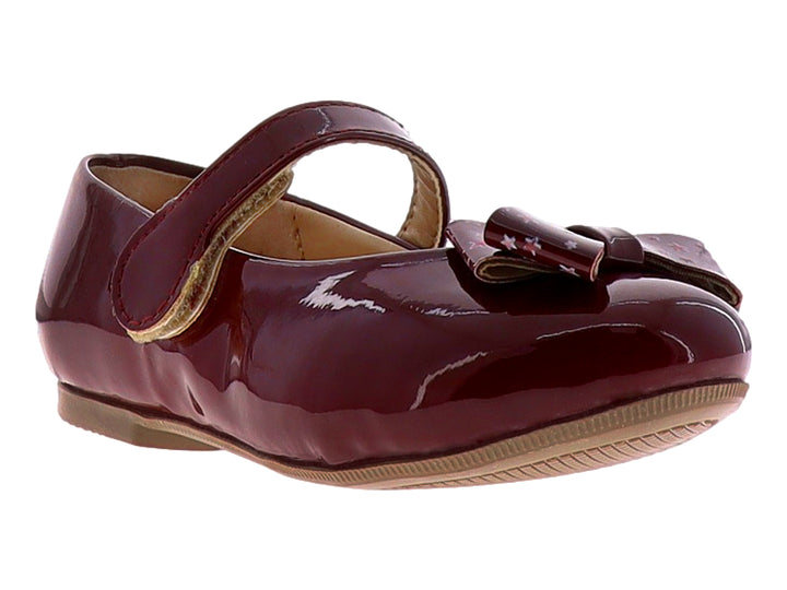 Zapato plano para niña en color rojo cereza brillante con detalle de moño y correa.