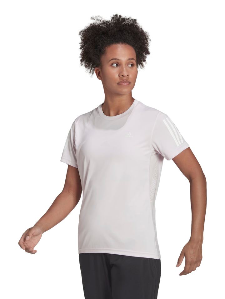 Mujer vistiendo playera deportiva Adidas color rosa pálido con tres franjas blancas en las mangas.