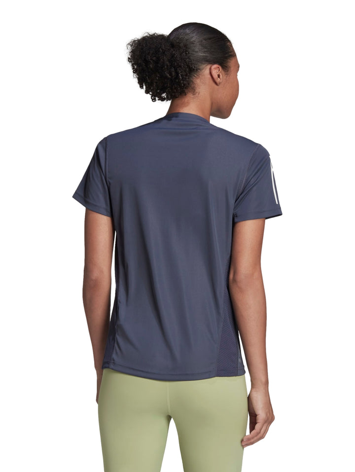 Mujer vistiendo playera deportiva Adidas color azul marino Shadow Navy con rayas blancas en las mangas.