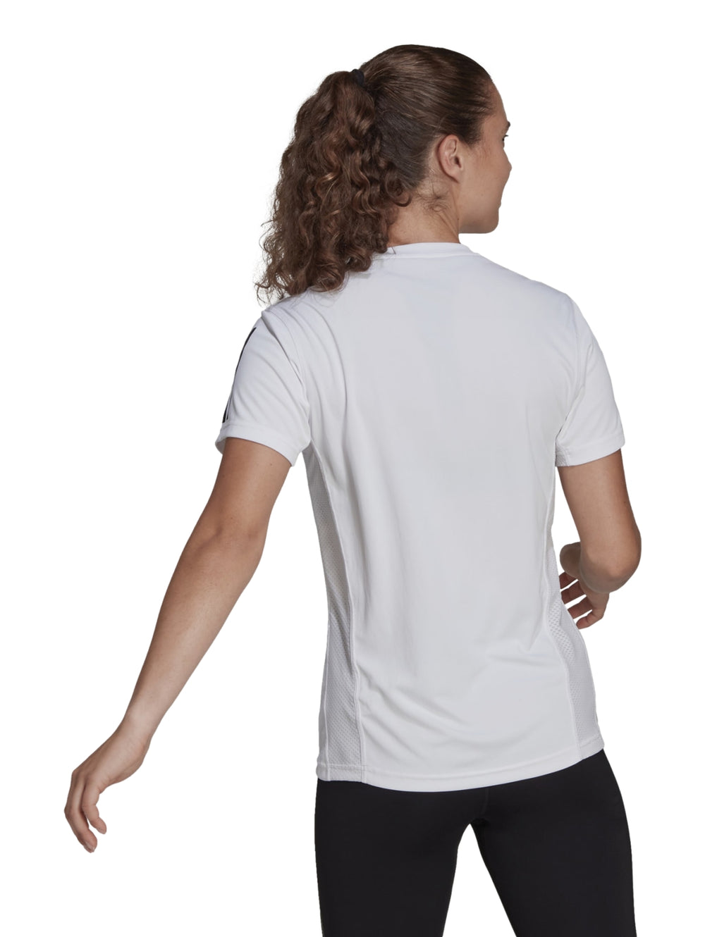 Mujer vistiendo playera deportiva Adidas blanca de manga corta con rayas negras en las mangas.