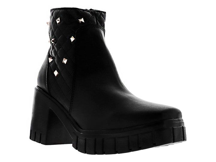Botas negras de tacón grueso y plataforma con detalles acolchados y tachuelas doradas en la parte posterior.