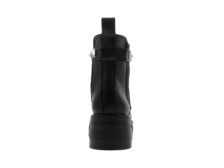 Bota negra de plataforma con correa decorada con tachuelas plateadas.