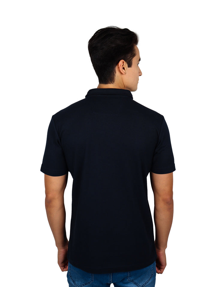 Hombre vistiendo playera polo negra con franjas horizontales en blanco y gris en el pecho.