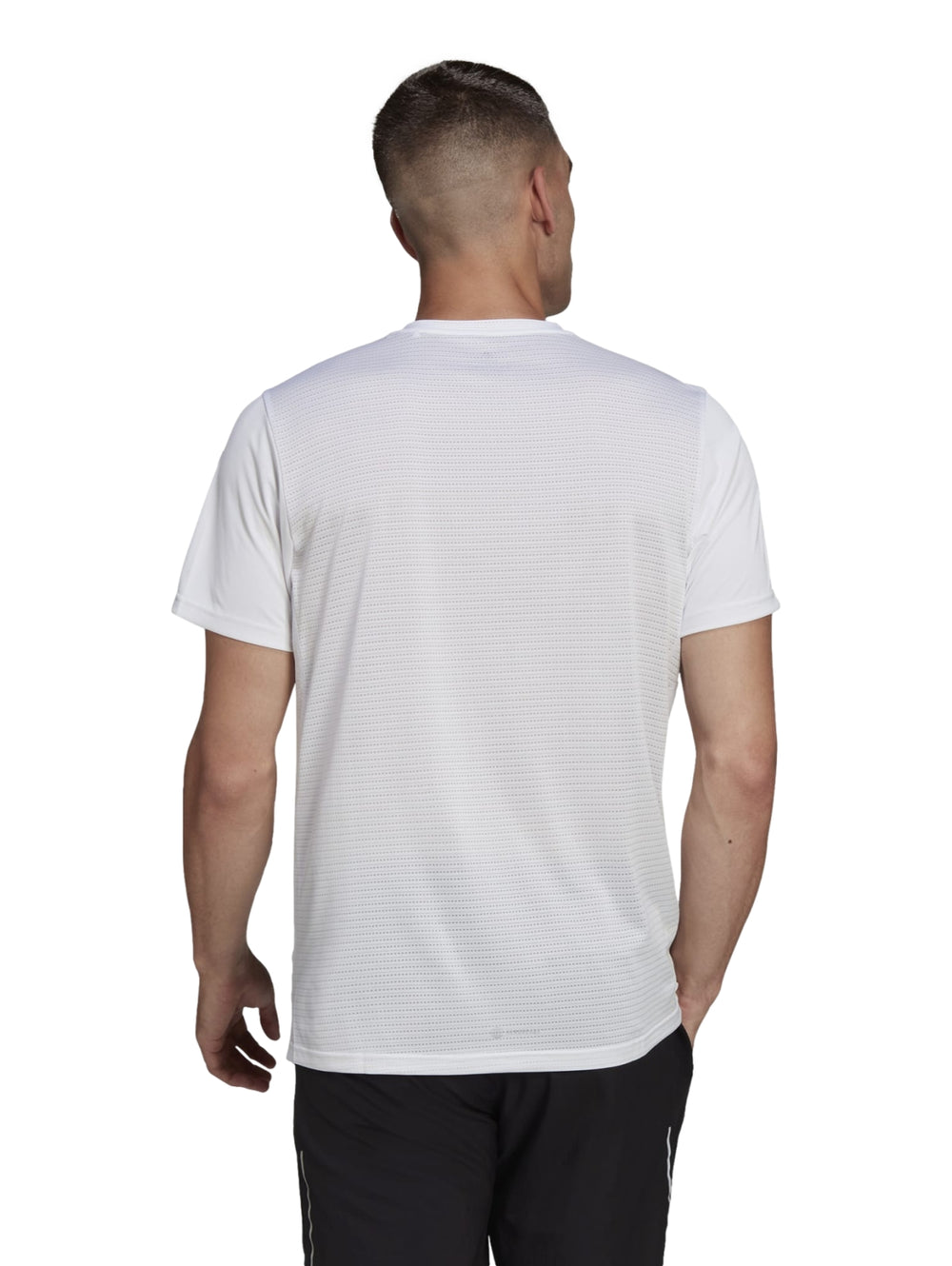 Hombre vistiendo camiseta deportiva blanca Adidas Own the Run con detalles laterales en los hombros.