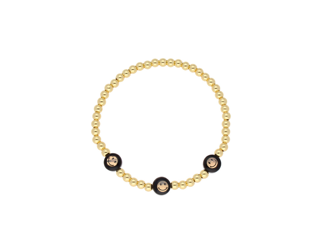 Pulsera de oro de Sandra Renteria compuesta por cuentas doradas y tres esferas negras decorativas.