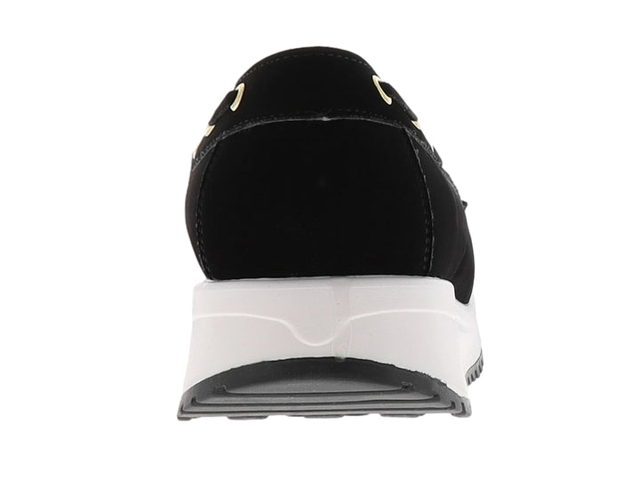 Mocasín negro para mujer con suela blanca y gris de plataforma y ojillos dorados.