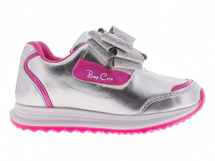 Tenis infantiles color plata con detalles en rosa y un moño brillante decorativo en la parte superior.