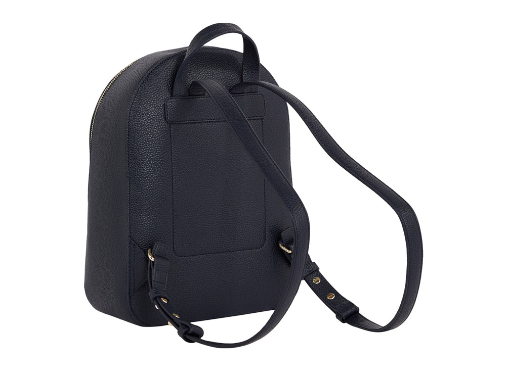Mujer con mochila azul marino con franja vertical blanca y roja de Tommy Hilfiger.