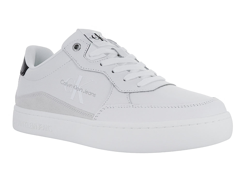 Tenis Calvin Klein blancos de cuero con detalle negro en el talón y suela blanca ancha.