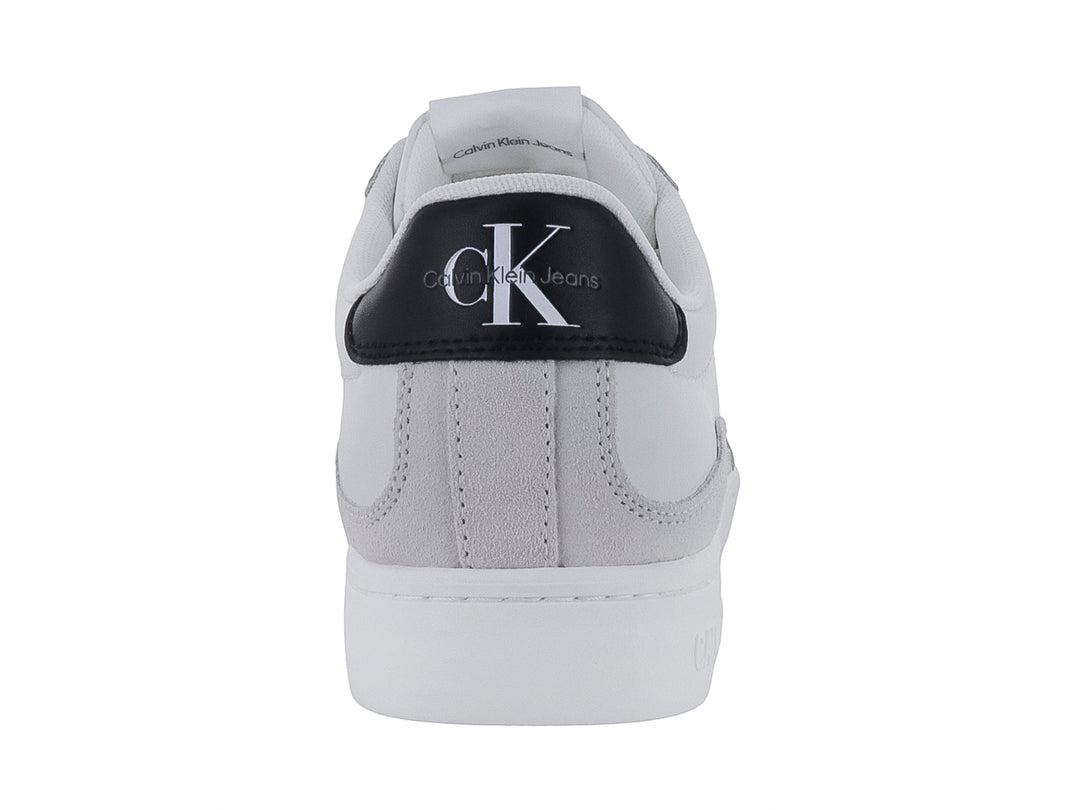 Tenis Calvin Klein blancos de cuero con detalle negro en el talón y suela blanca ancha.