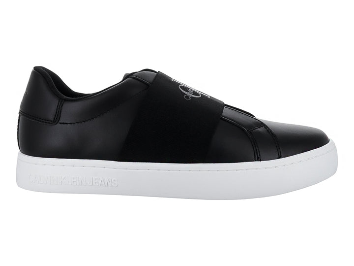 Tenis Calvin Klein color negro con suela blanca y banda elástica frontal, estilo casual slip-on.