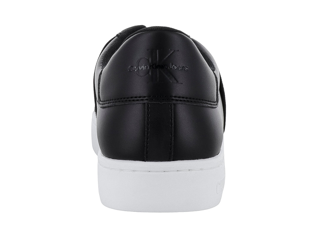 Tenis Calvin Klein color negro con suela blanca y banda elástica frontal, estilo casual slip-on.