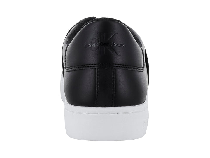 Tenis Calvin Klein color negro con suela blanca y banda elástica frontal, estilo casual slip-on.