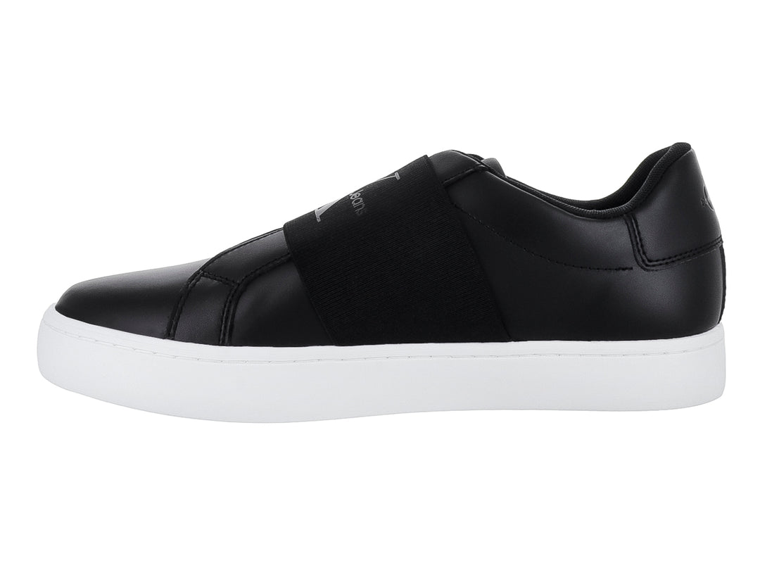 Tenis Calvin Klein color negro con suela blanca y banda elástica frontal, estilo casual slip-on.