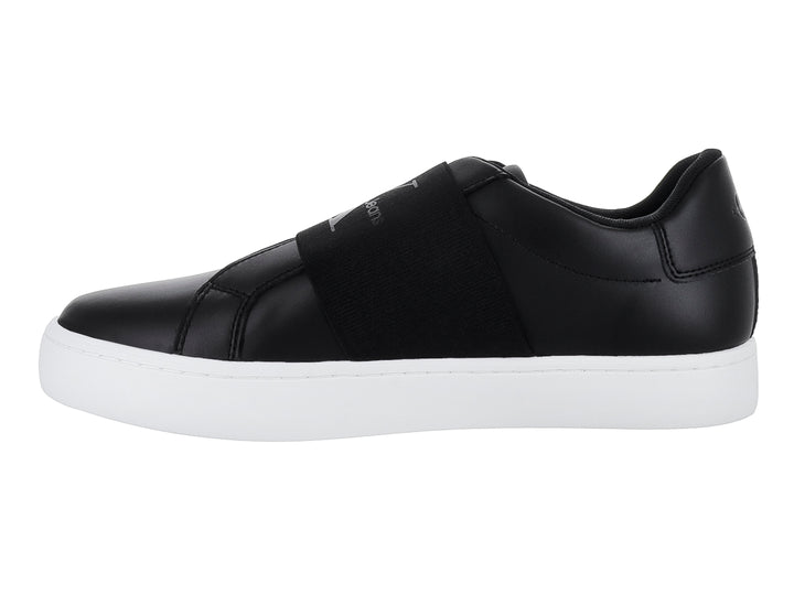 Tenis Calvin Klein color negro con suela blanca y banda elástica frontal, estilo casual slip-on.