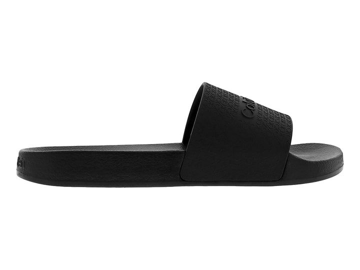 Sandalia deslizante color negro de la marca Calvin Klein con correa texturizada y logo grabado.