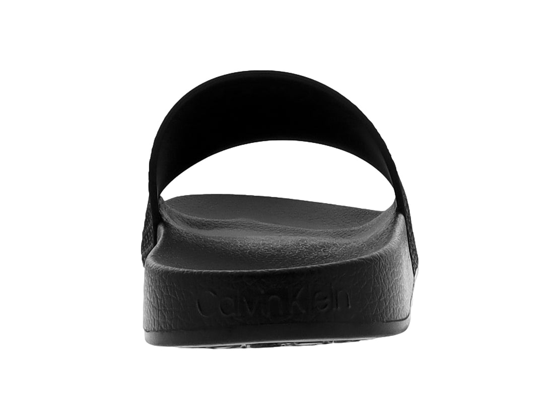 Sandalia deslizante color negro de la marca Calvin Klein con correa texturizada y logo grabado.