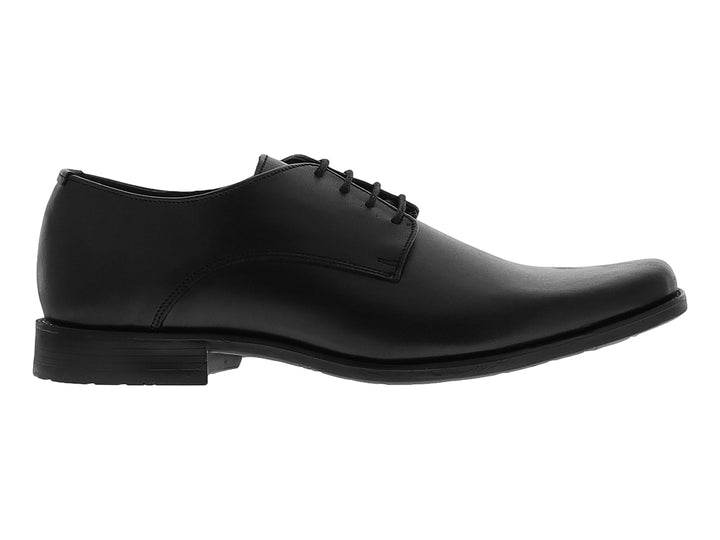 Zapato formal negro de material sintético con cordones y suela plana para niño.