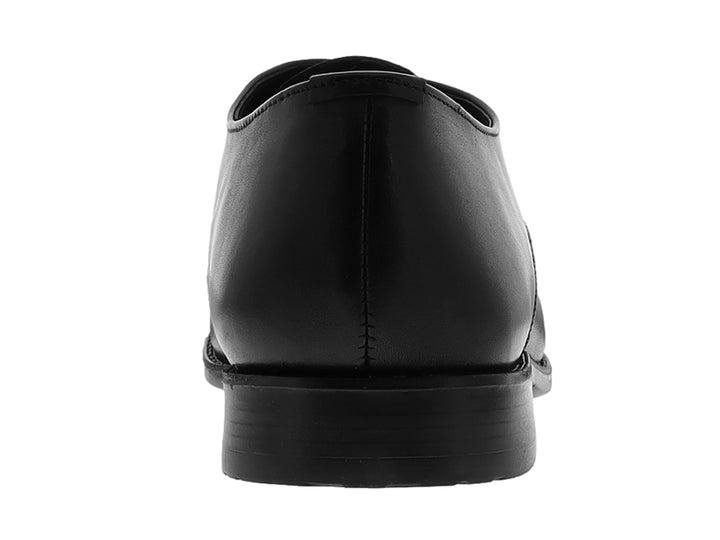 Zapato formal negro de material sintético con cordones y suela plana para niño.