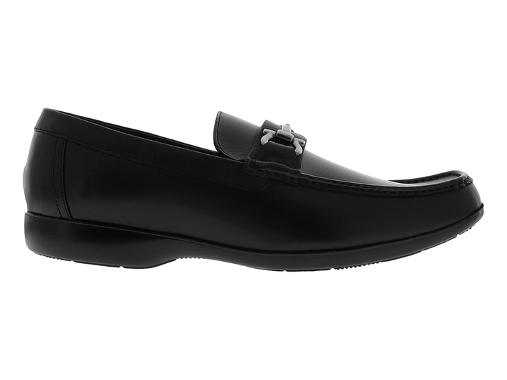 Zapato tipo mocasín color negro con hebilla metálica plateada sobre fondo blanco.