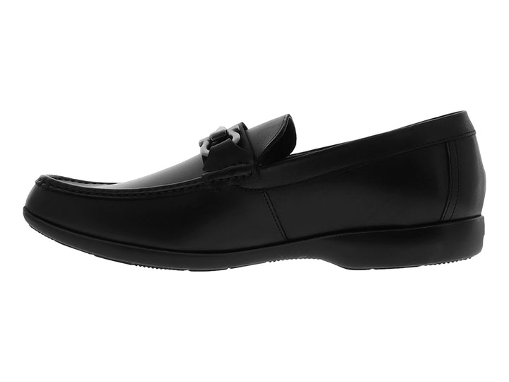 Zapato tipo mocasín color negro con hebilla metálica plateada sobre fondo blanco.