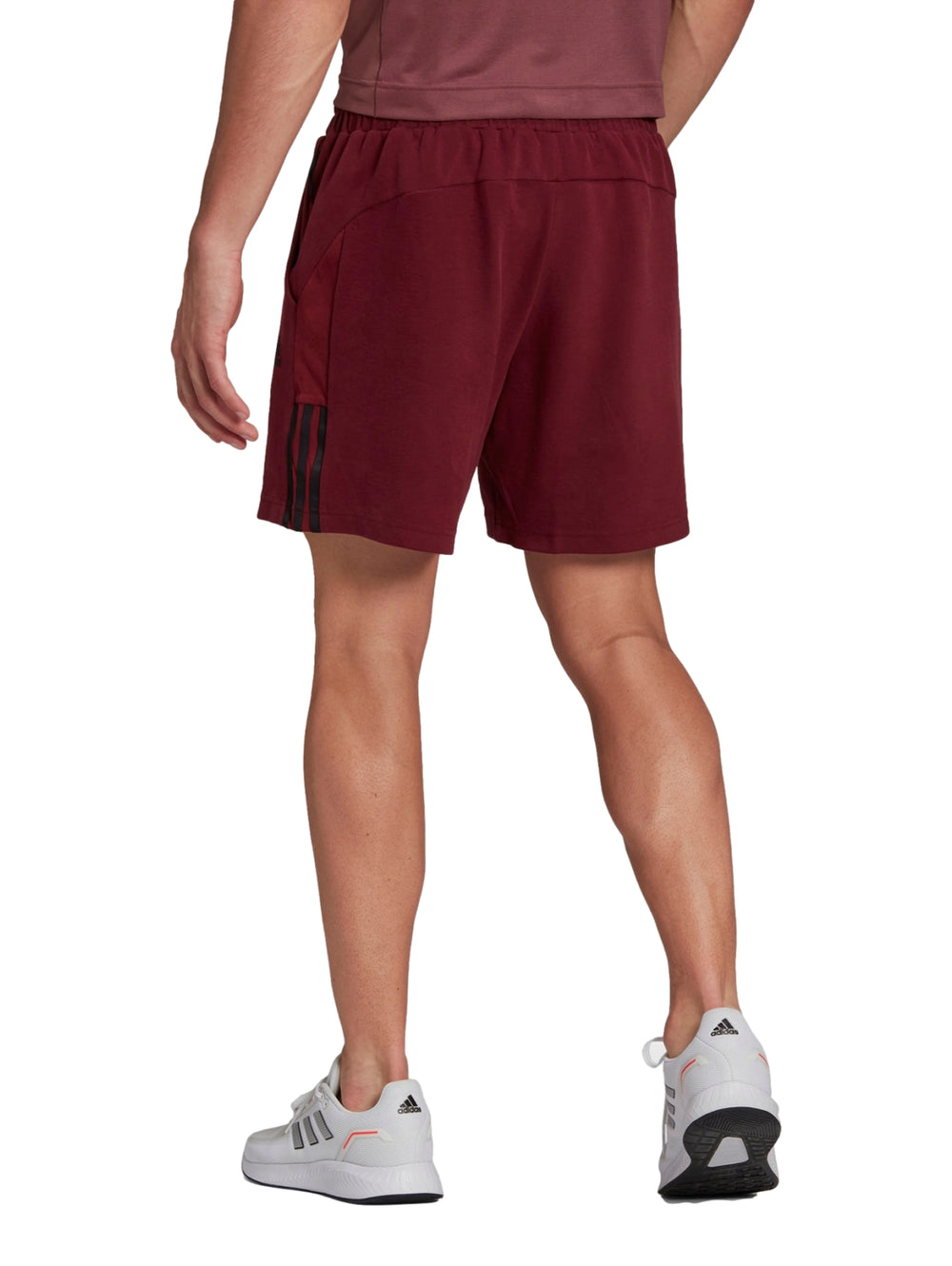 Hombre usando shorts deportivos Adidas en color rojo oscuro.