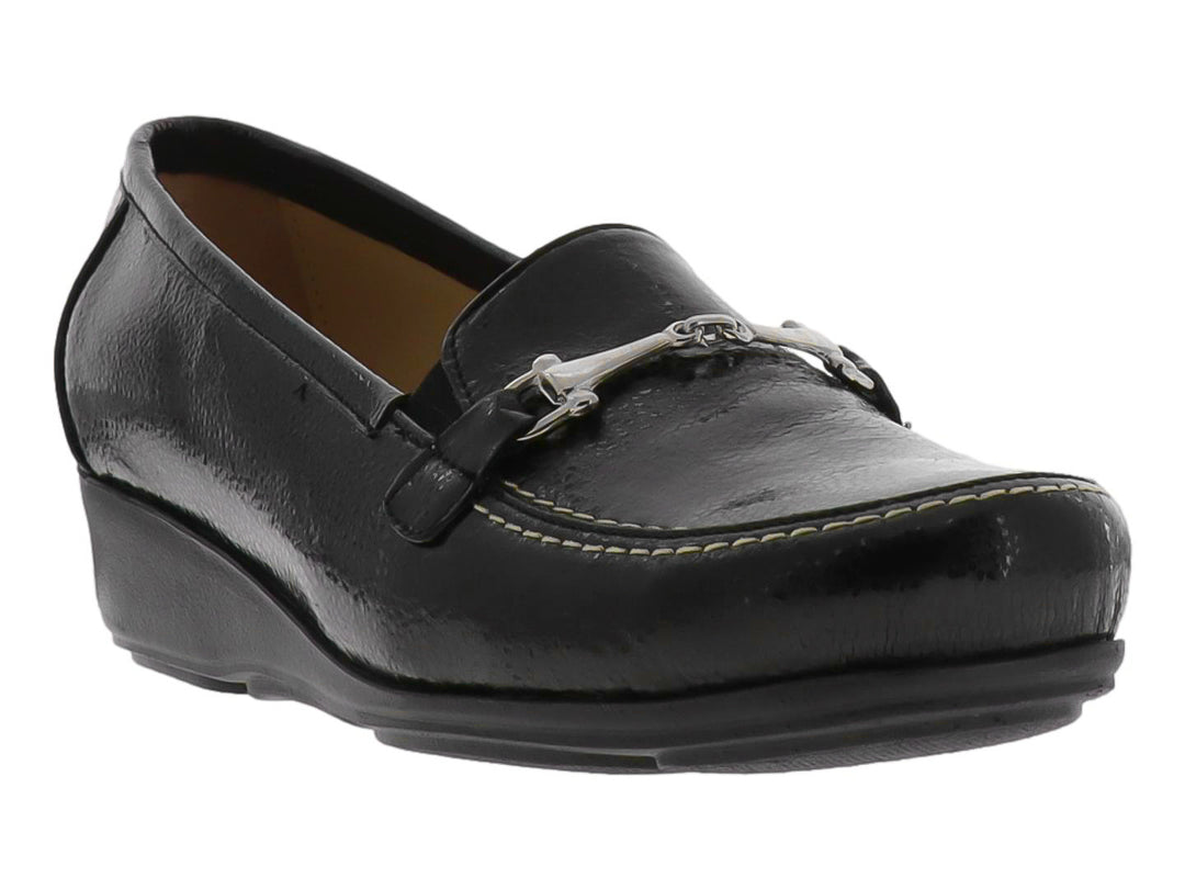 Zapato tipo mocasín color negro brillante con adorno metálico plateado en la parte superior.