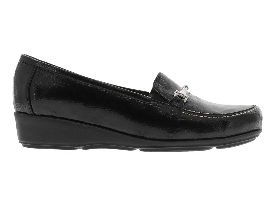 Zapato tipo mocasín color negro brillante con adorno metálico plateado en la parte superior.