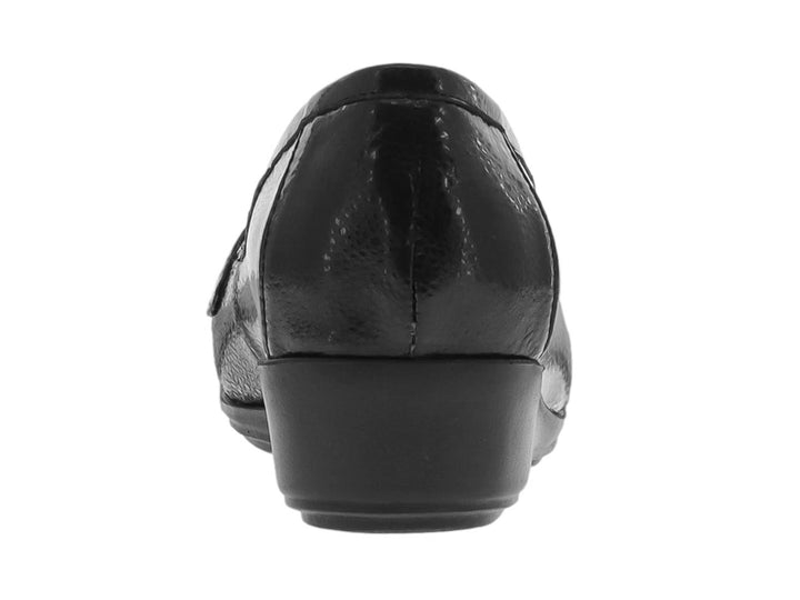 Zapato tipo mocasín color negro brillante con adorno metálico plateado en la parte superior.