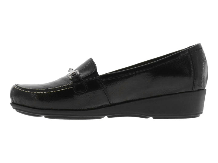Zapato tipo mocasín color negro brillante con adorno metálico plateado en la parte superior.