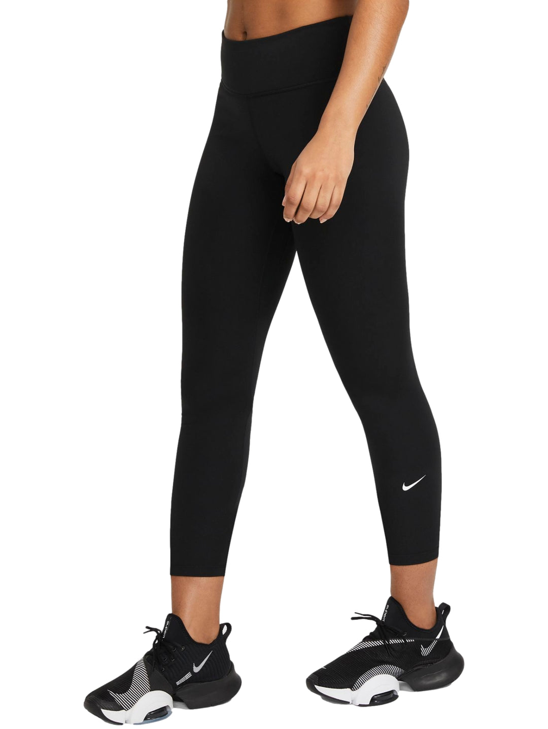 Mujer vistiendo leggings deportivos Nike color negro, corte cropped y tenis negros.