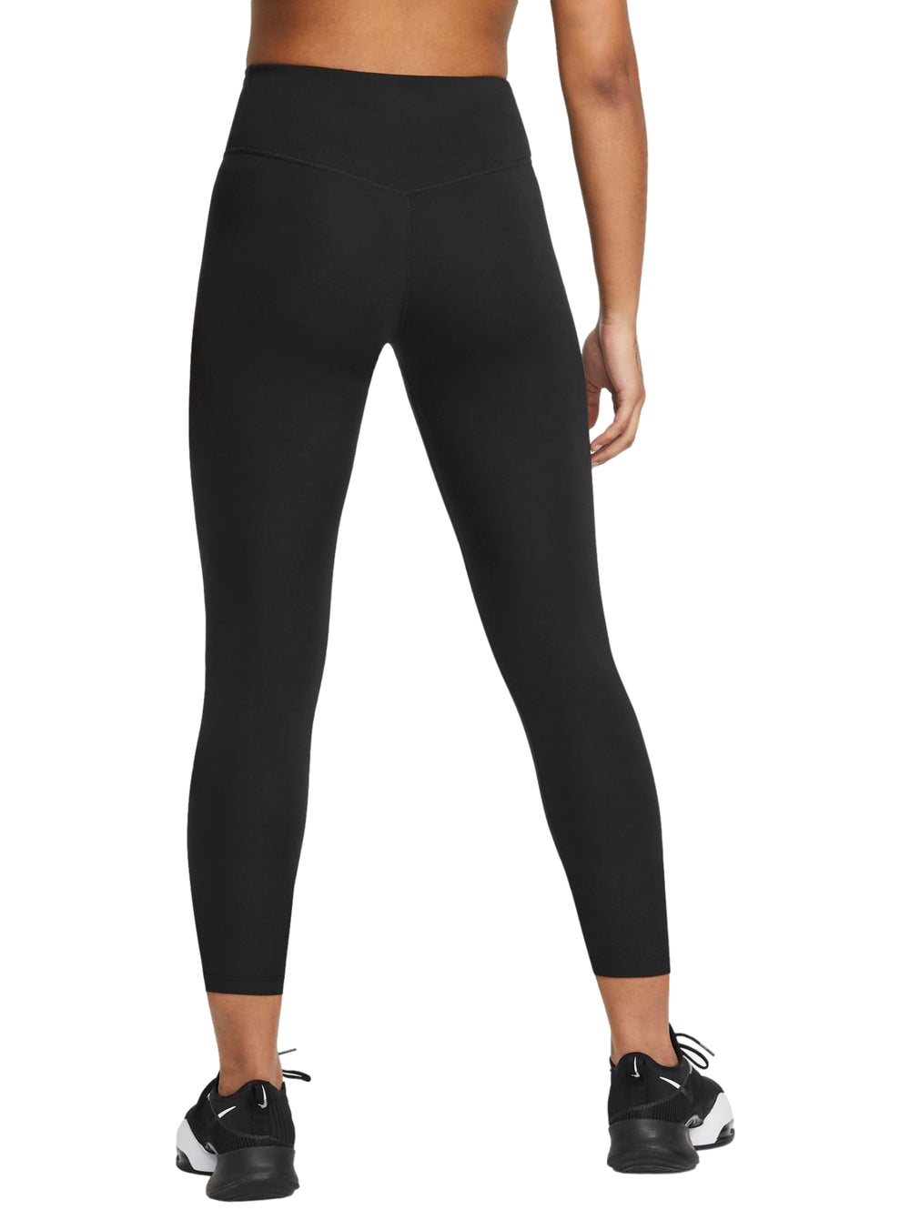 Mujer vistiendo leggings deportivos Nike color negro, corte cropped y tenis negros.