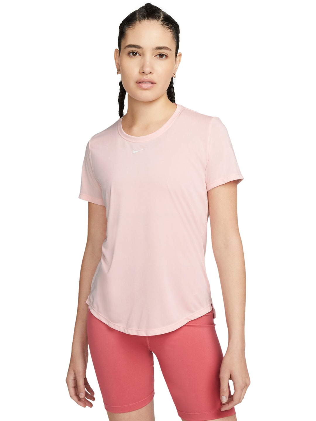 Mujer vistiendo camiseta deportiva Nike de color rosa claro y manga corta.