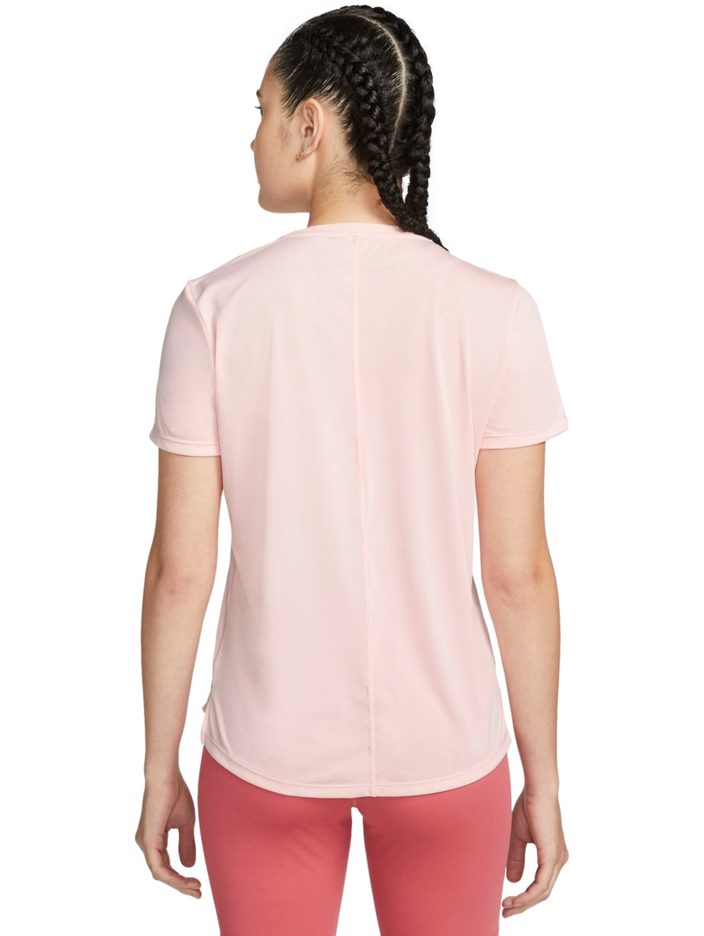 Mujer vistiendo camiseta deportiva Nike de color rosa claro y manga corta.
