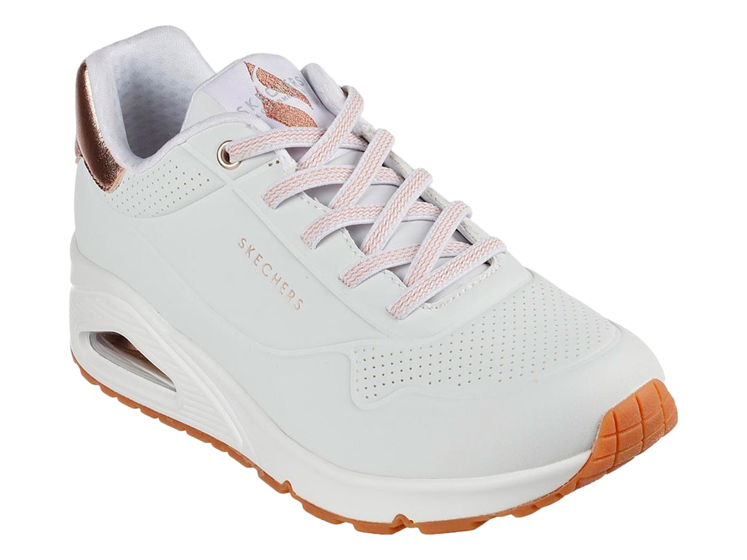 Tenis deportivos Skechers blancos con detalles dorados en el talón y suela blanca con cámara de aire.