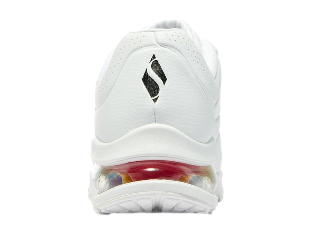 Tenis deportivos Skechers blancos con detalles de graffiti multicolor y suela amortiguada arcoíris.