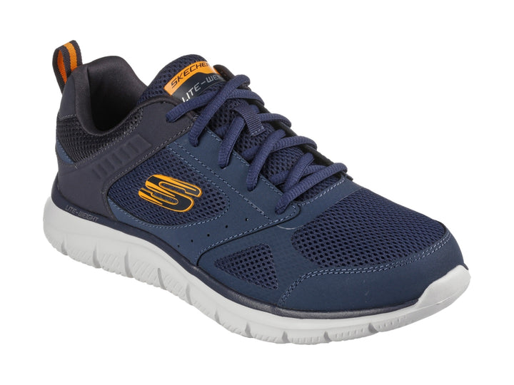 Tenis deportivos Skechers color azul marino con suela blanca y detalles naranjas.