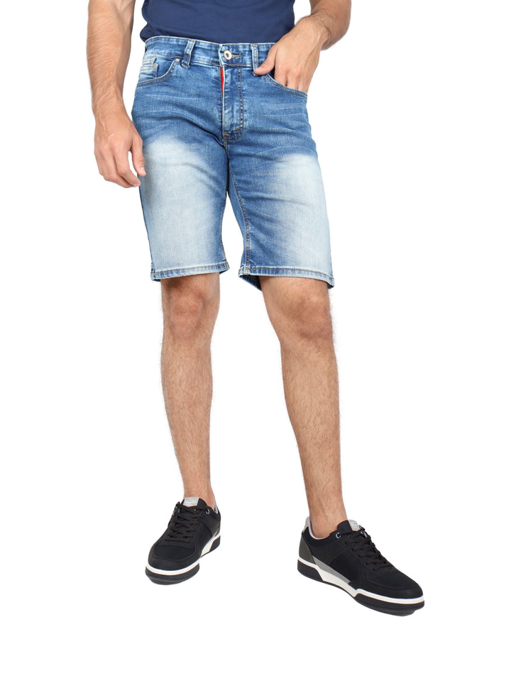 Hombre vistiendo bermudas de mezclilla color stone y tenis negros.