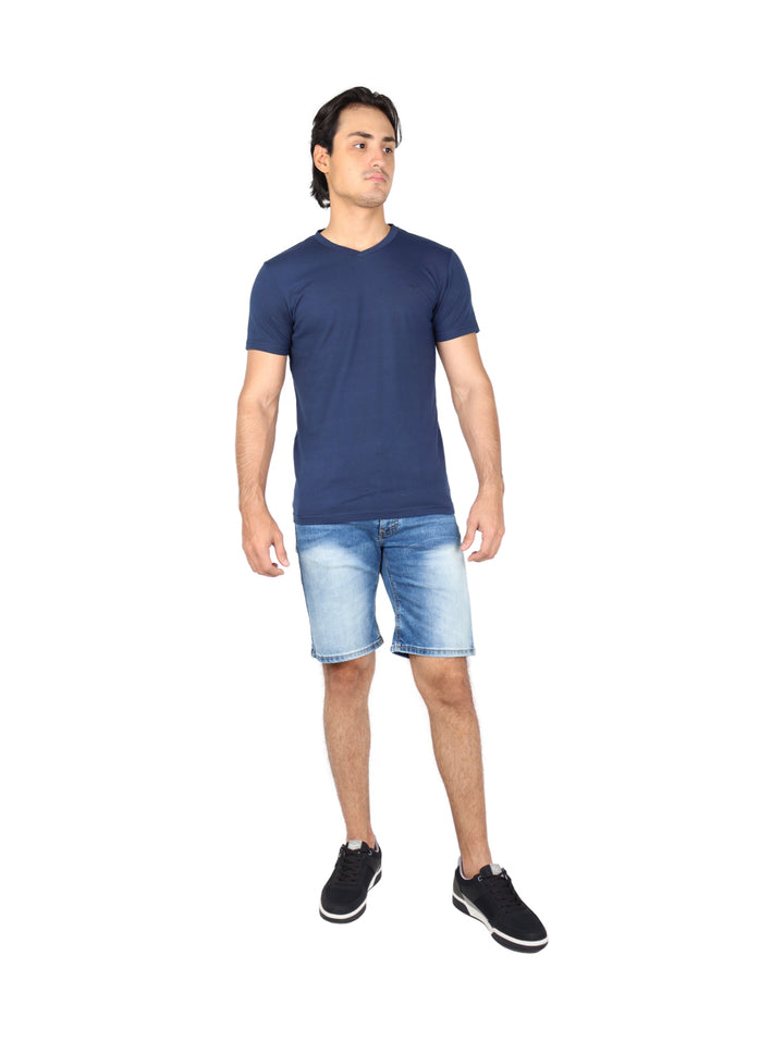 Hombre vistiendo bermudas de mezclilla color stone y tenis negros.