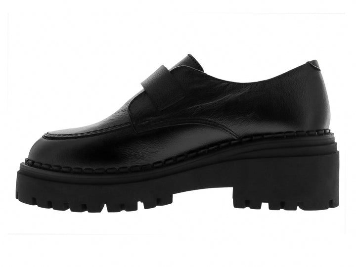Mocasines negros para mujer con suela track gruesa y hebilla metálica plateada.