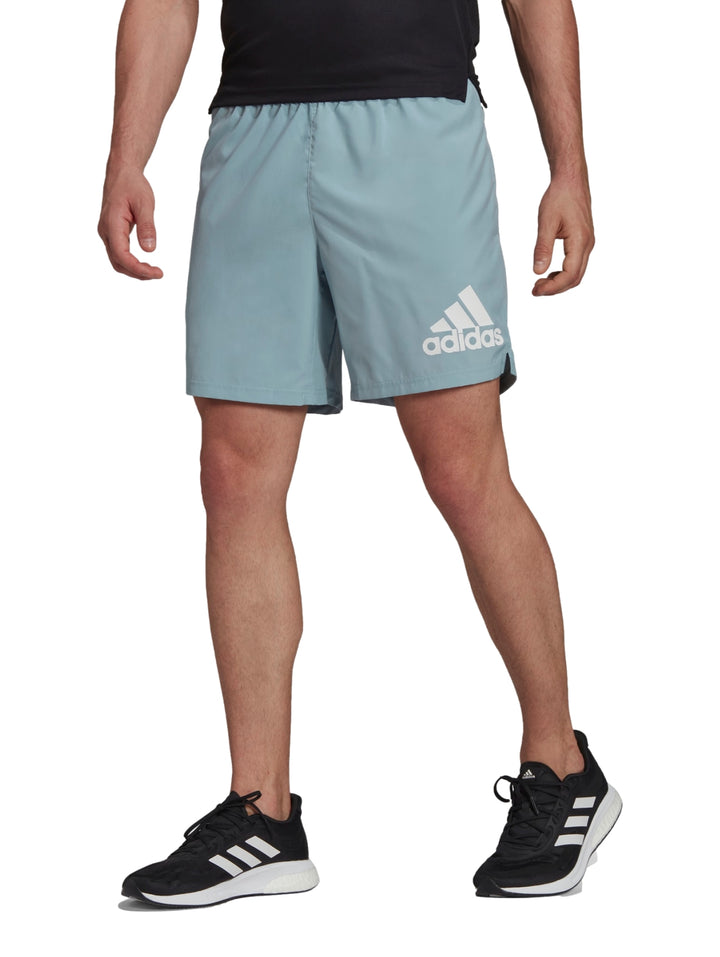Hombre usando shorts deportivos Adidas color gris Magic Grey.