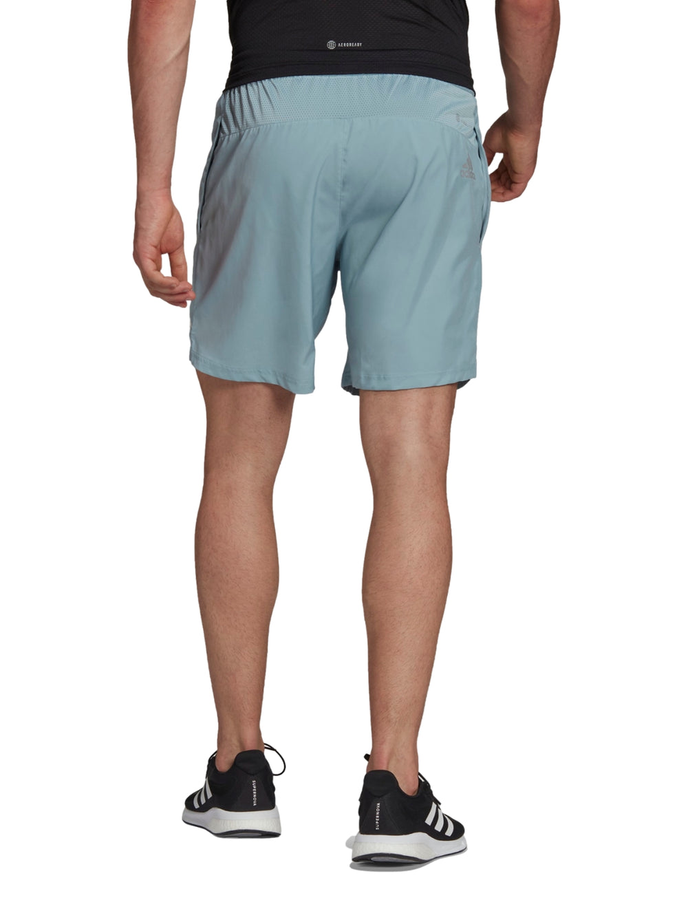 Hombre usando shorts deportivos Adidas color gris Magic Grey.