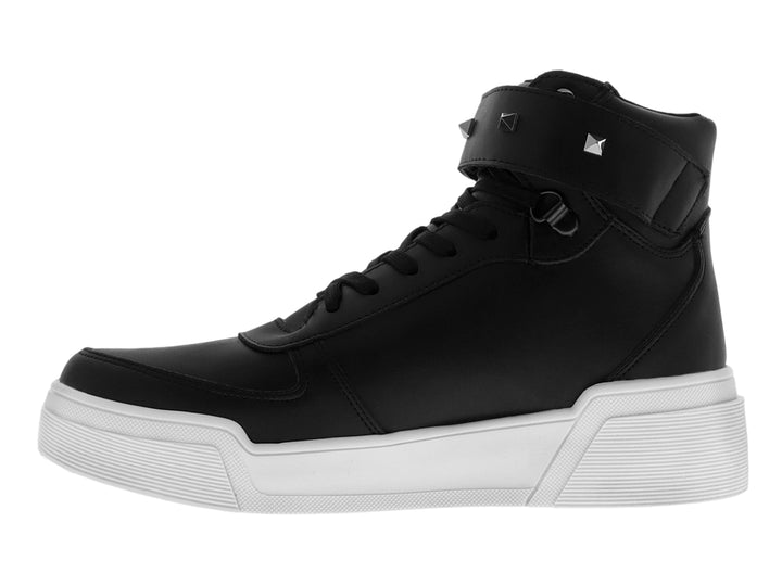 Tenis negros de bota alta con suela blanca gruesa y correa superior decorada con tachuelas metálicas.