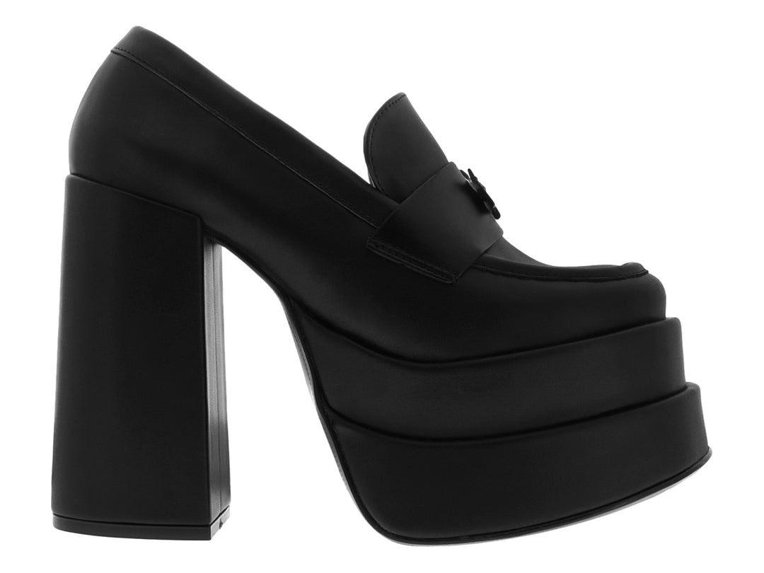 Zapato negro de plataforma con tacón grueso y detalle decorativo frontal.
